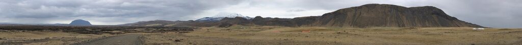 Wide tundra plain with low ridges and a distant road (Ásahreppur)
