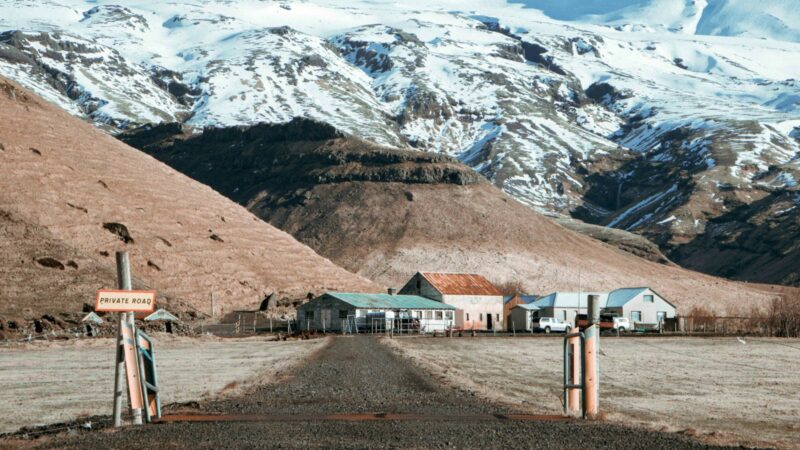 Farm buildings beneath snow‑dusted mountains