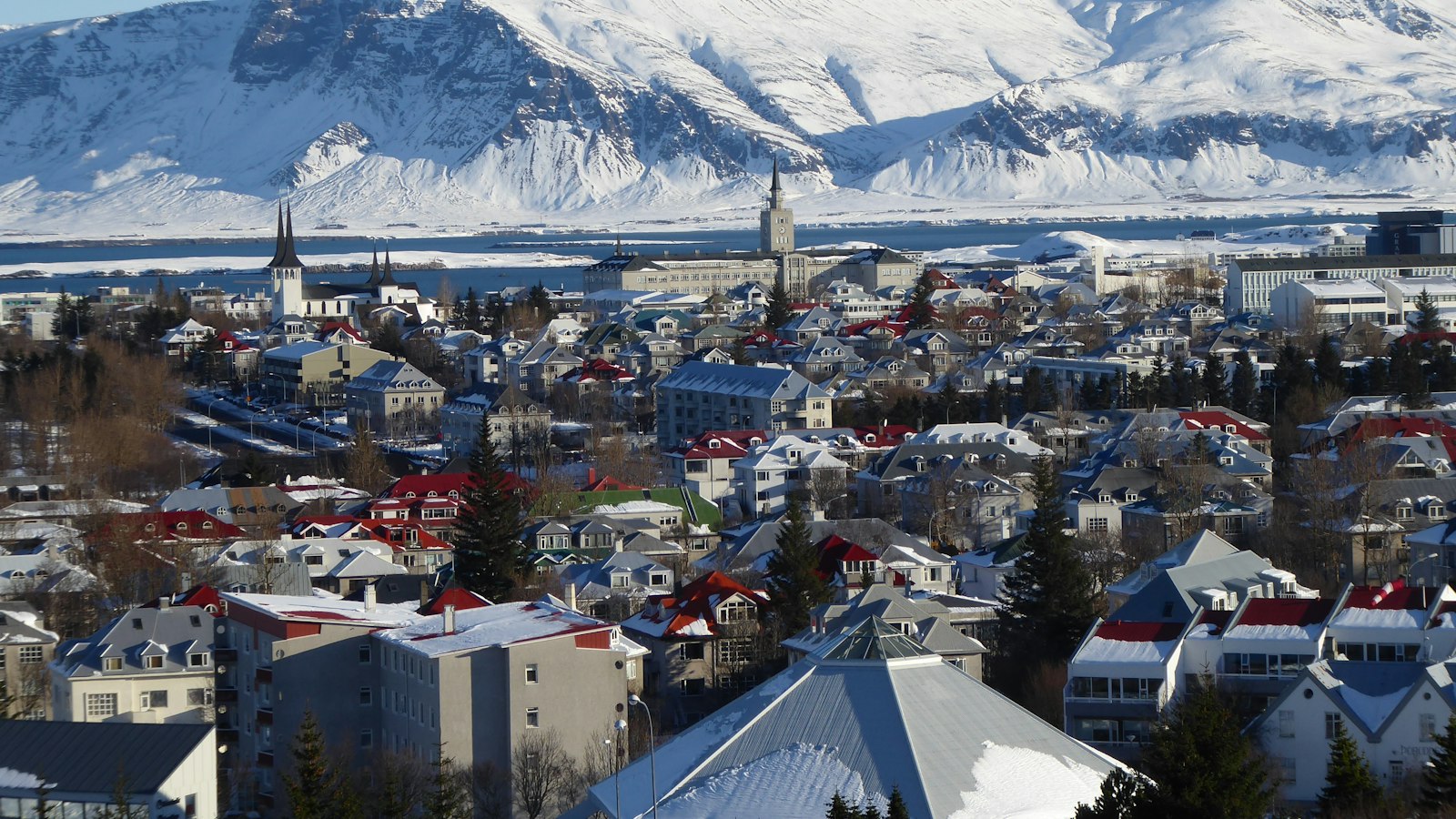 Panoramic view of a city with snow-covered mountains behind