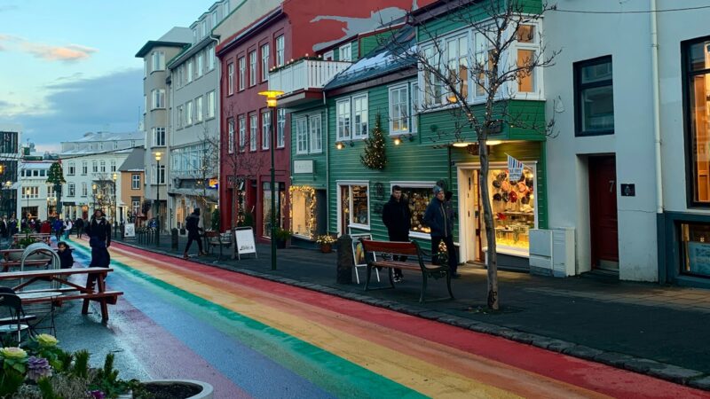 Pedestrian street with rainbow-painted road and shopfronts