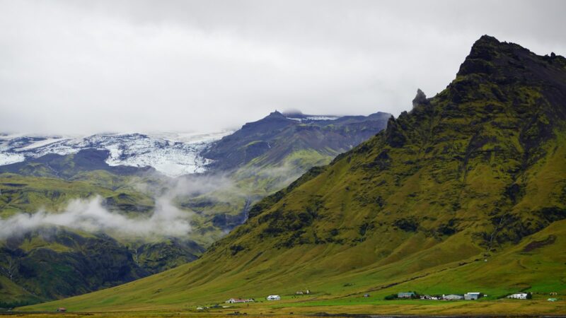 Valley with green slopes and a glacier in the background