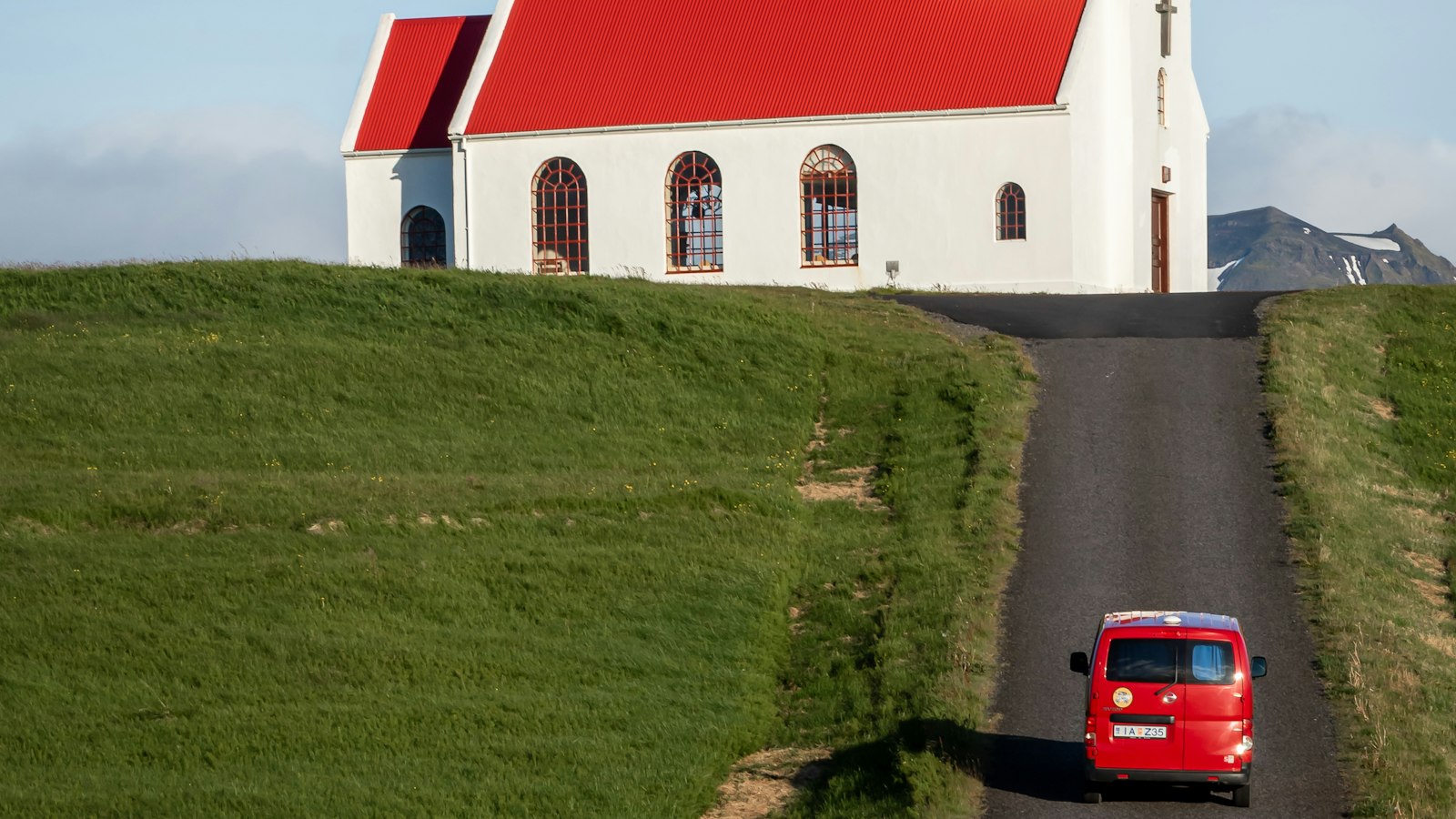 A red-roofed country church under a glacier
