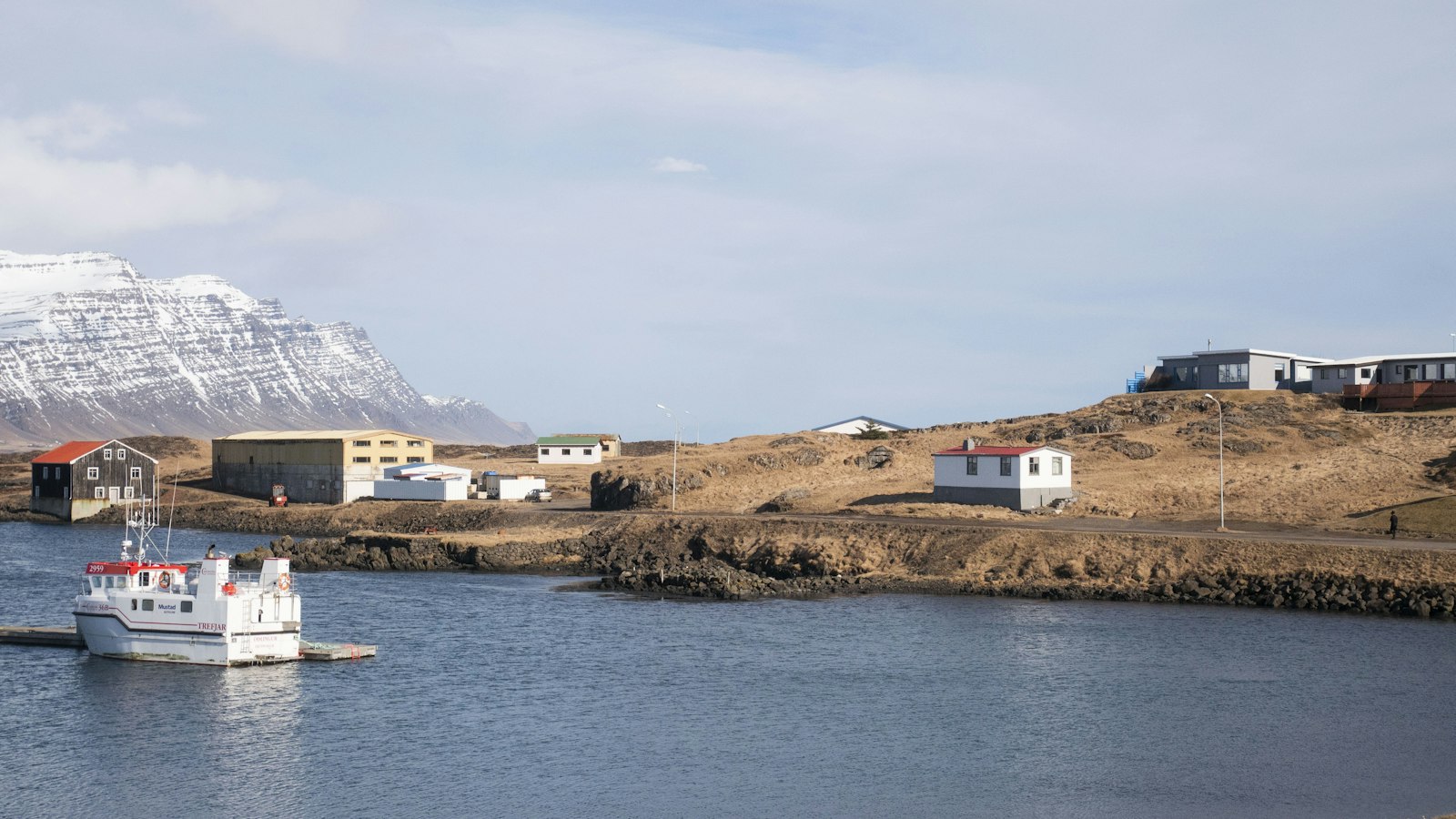 A small ferry arriving at an island harbour