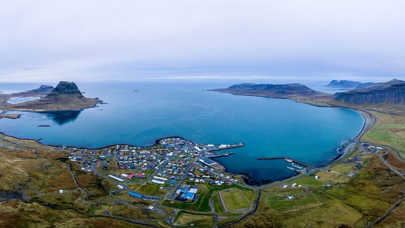 Aerial view of town by a bay with a conical mountain in the distance (Grundarfjörður)