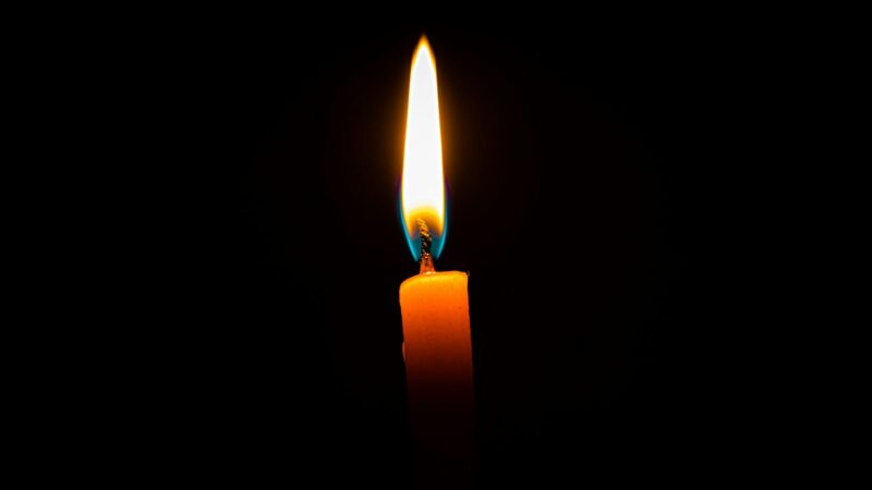 A single candle burning in the dark