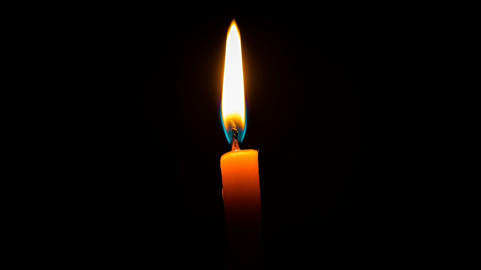 A single candle burning in the dark