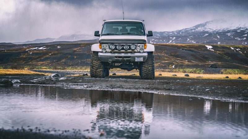 A modified super jeep crossing a river in the highlands