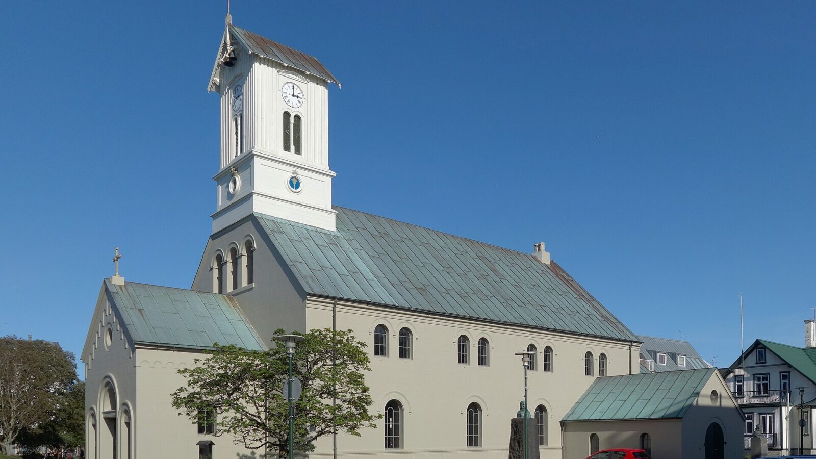 Close-up of church tower and roof against blue sky (Alþingi)