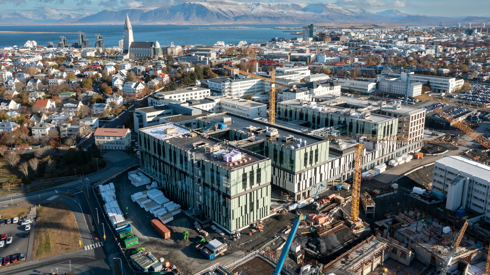Aerial view of large construction site and surrounding city