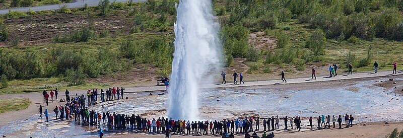 Geyser eruption with a ring of spectators around it (Bláskógabyggð)
