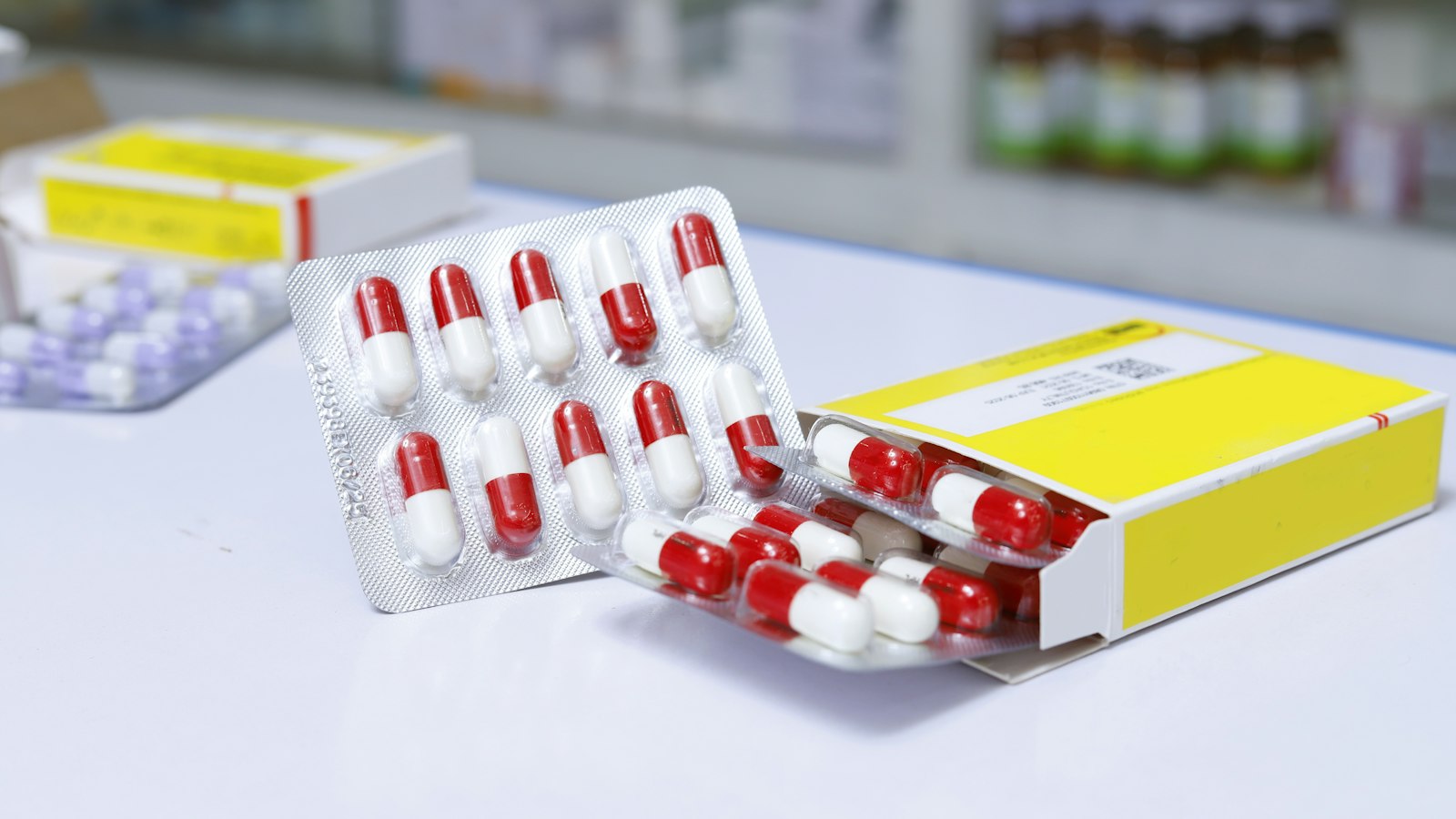 Blister packs of red-and-white capsules on a counter