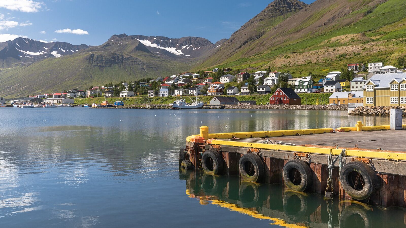 Harbour quay foreground with houses on the hillside and mountains (Siglufjörður)