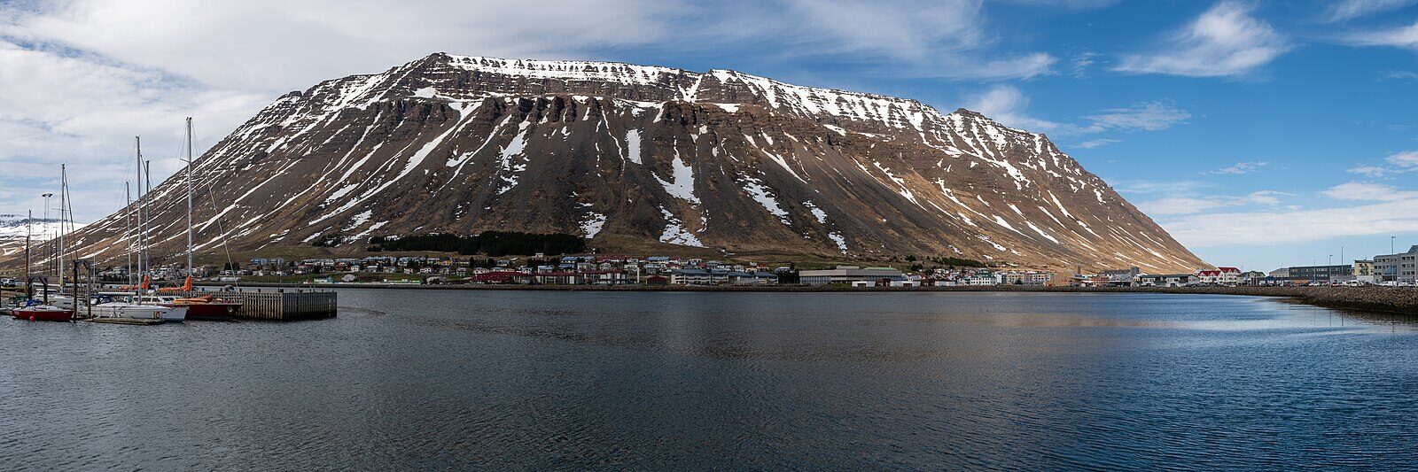 Harbour with moored yachts and a large mountain backdrop