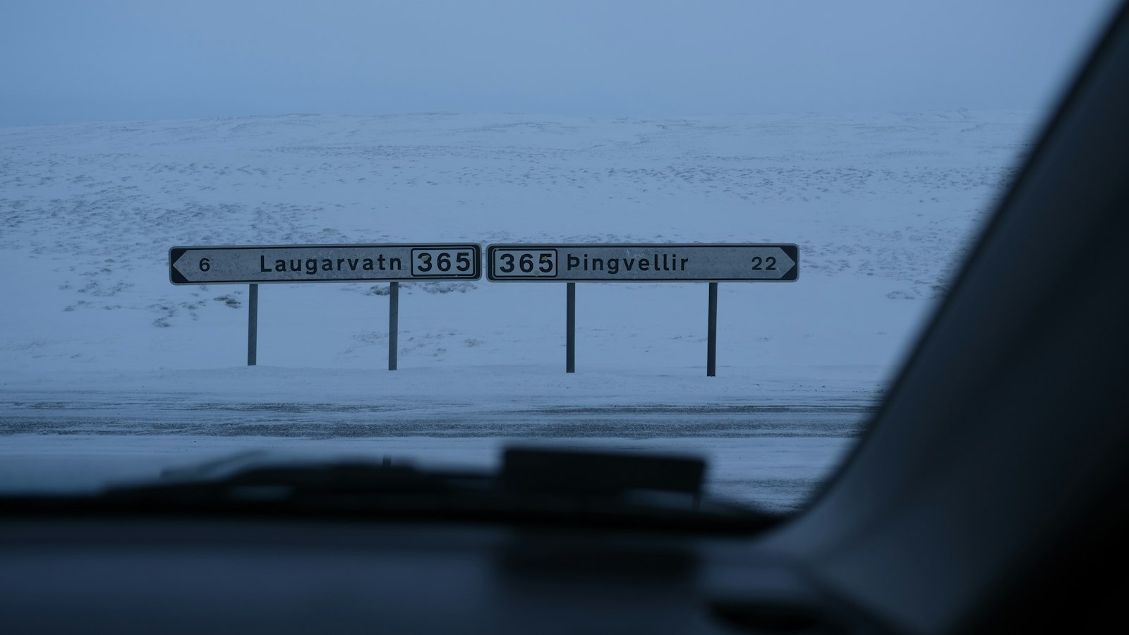 Road signs seen through a windscreen in snowy landscape