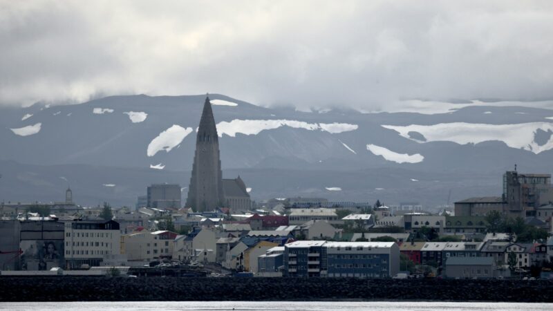 The skyline with a tall church tower and mountains behind
