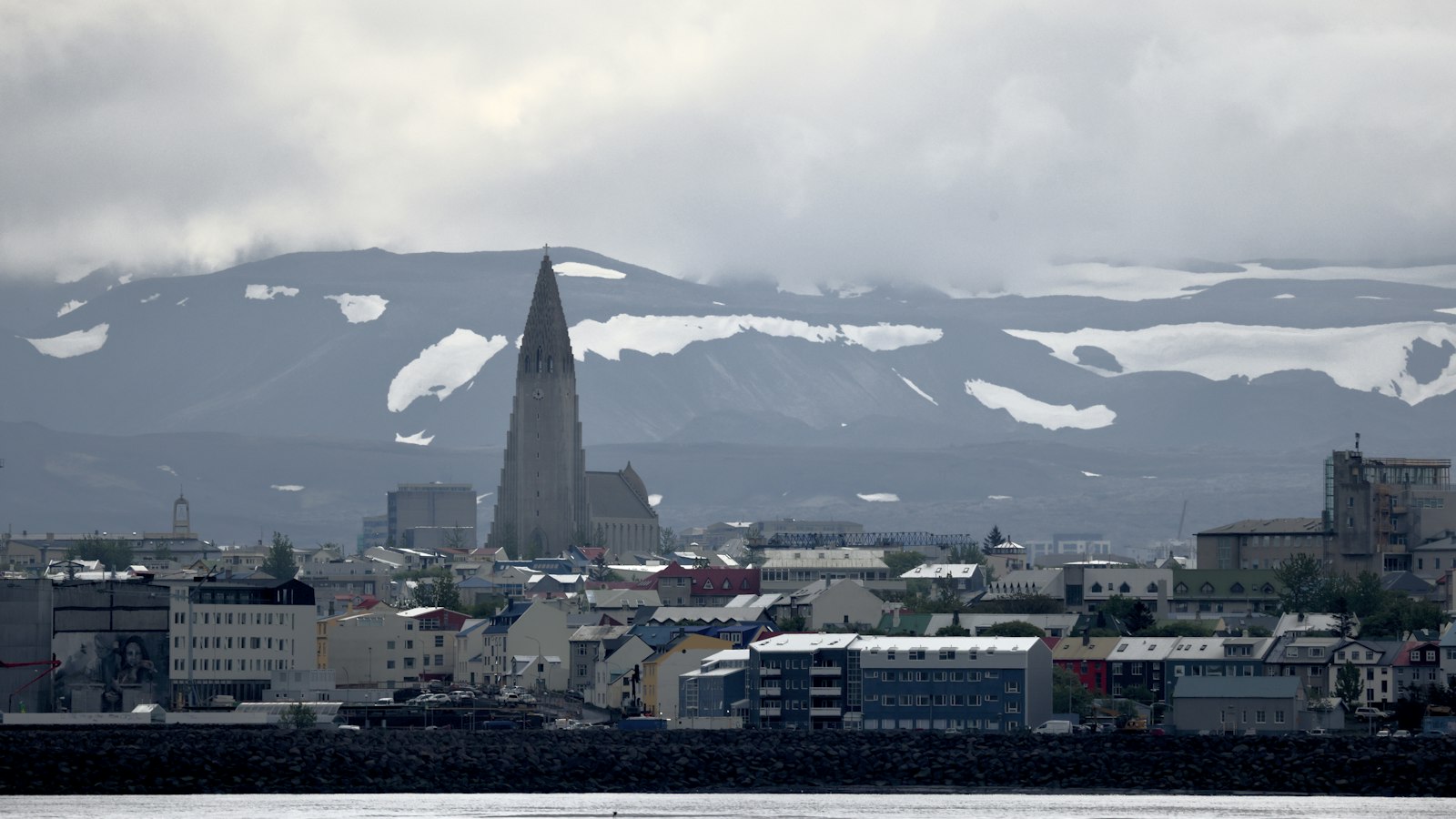 The skyline with a tall church tower and mountains behind