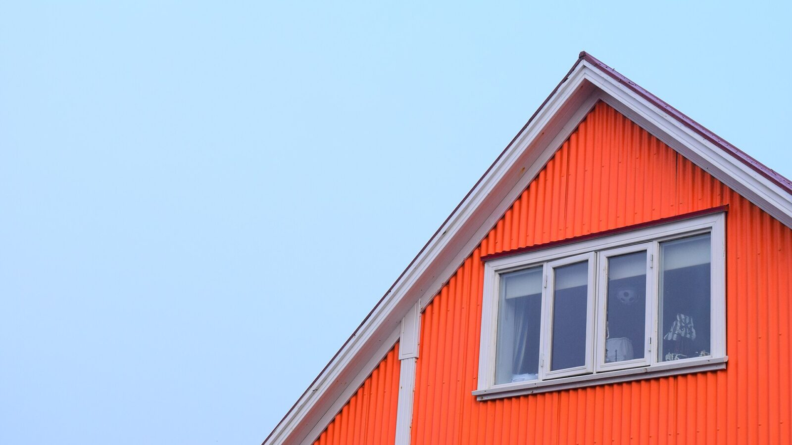 Upper gable and windows of an orange corrugated house (Landspítali)
