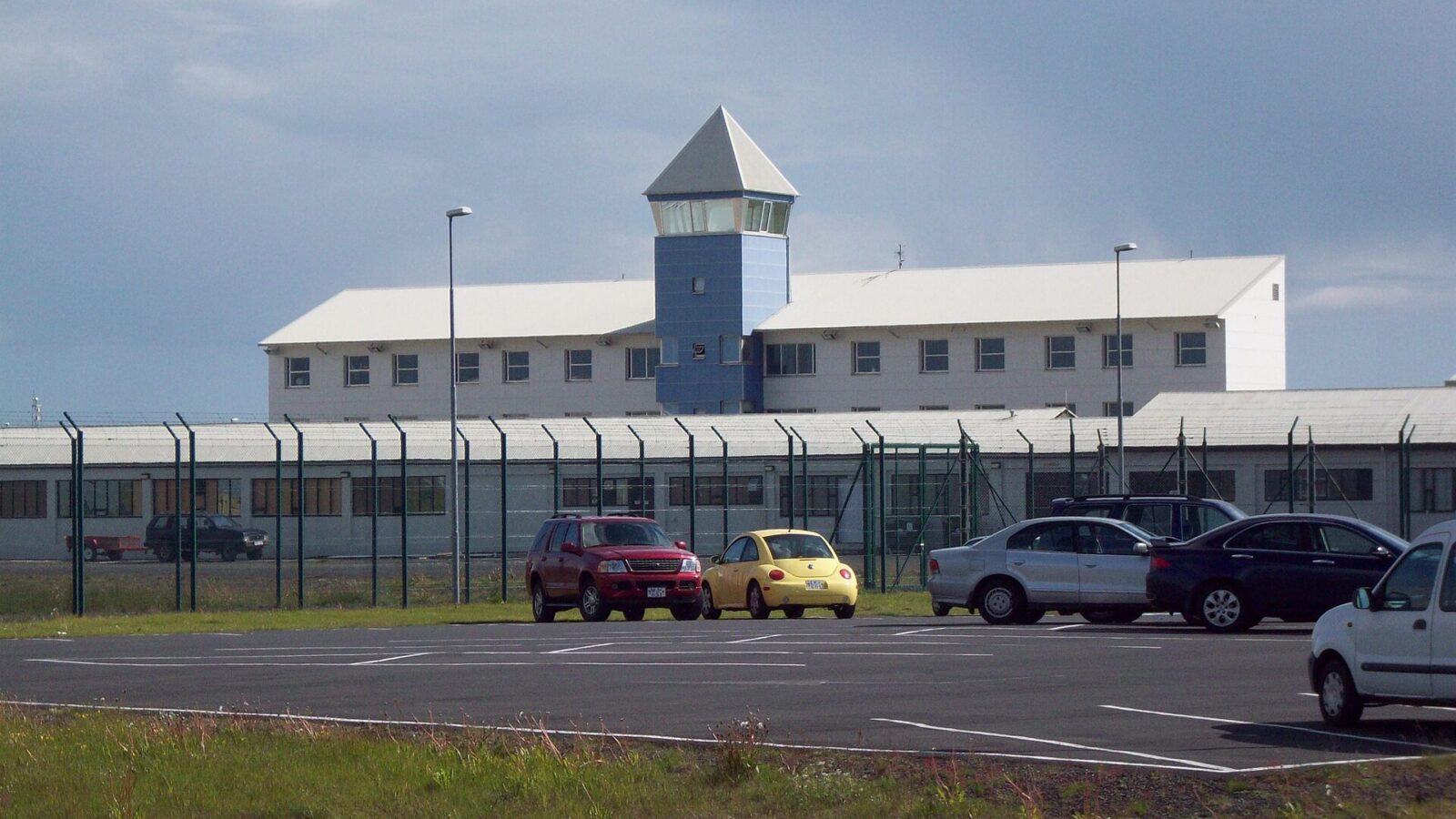 Low-rise building with watch tower and perimeter fence
