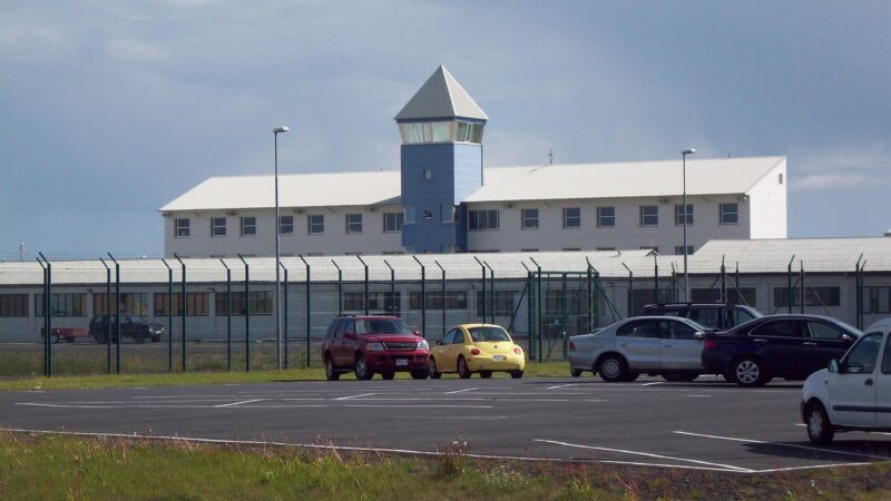 Low-rise building with watch tower and perimeter fence