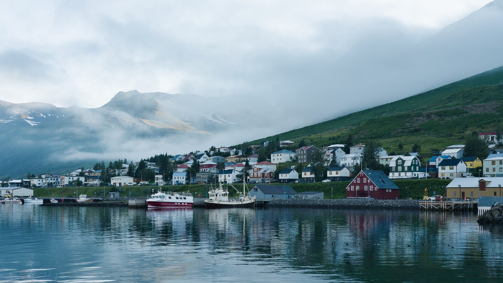Low cloud and mist rolling over houses and harbour (Siglufjörður)