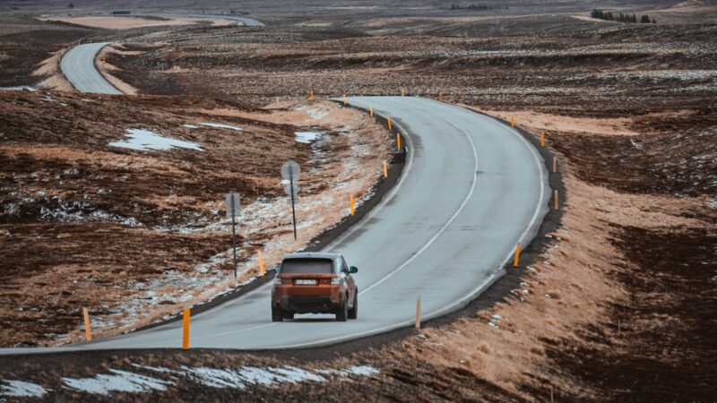 Car driving on a winding road across moorland