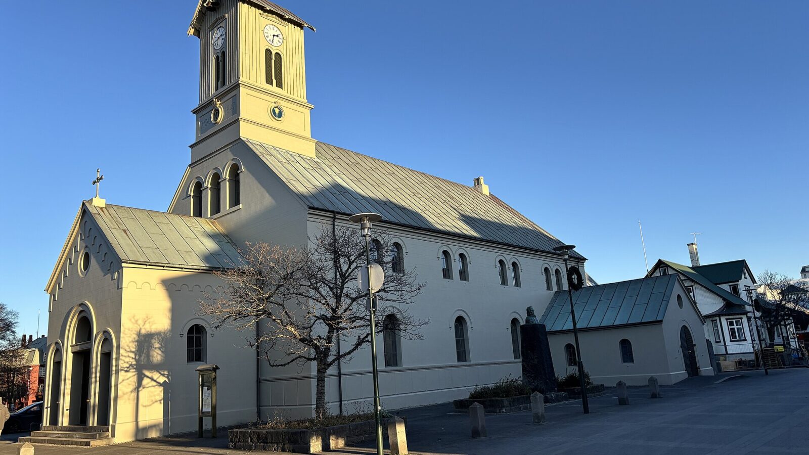 Close view of a church tower and roof against a clear sky (Alþingi)