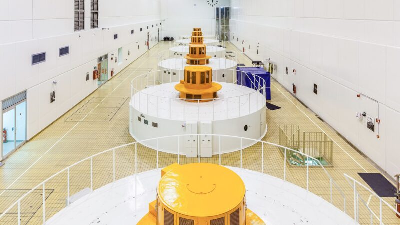 Interior of a turbine hall showing generator housings in a long white room (Landsvirkjun)