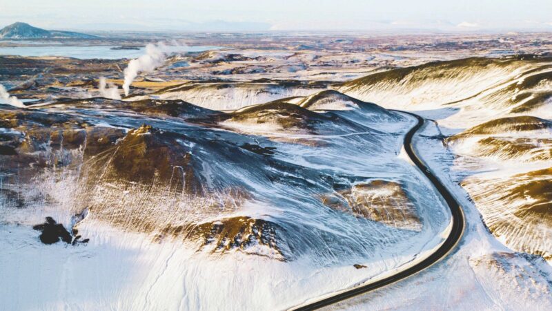 Aerial view of a winding road through snow-covered hills