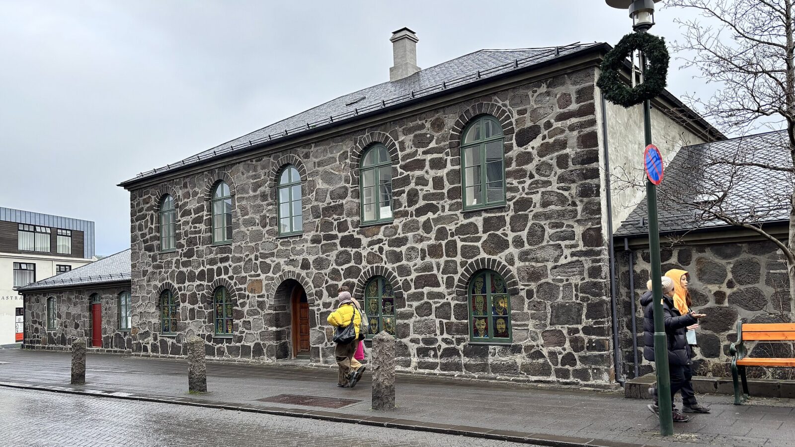 Stone building façade with arched windows and stained-glass panels (Hegningarhúsið)