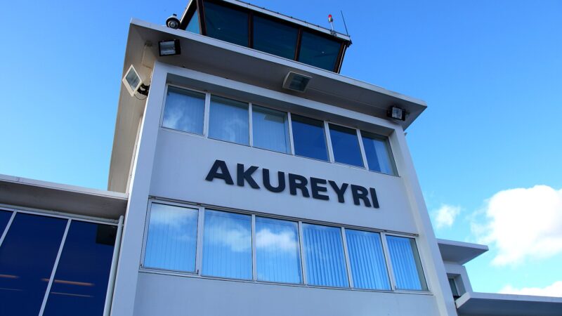 White building with large 'AKUREYRI' sign and upper control tower