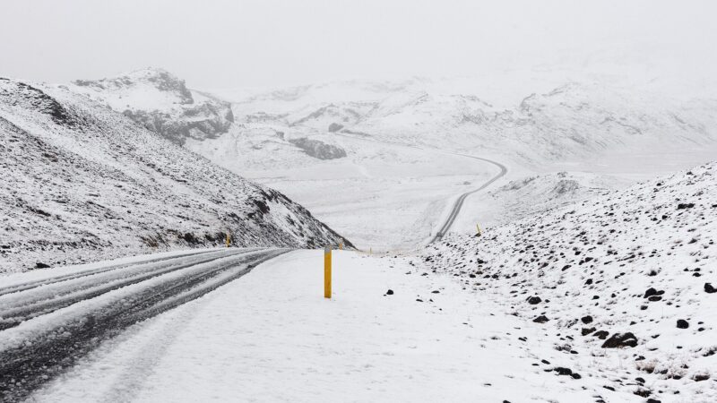 Snow-covered road and hills in a whiteout