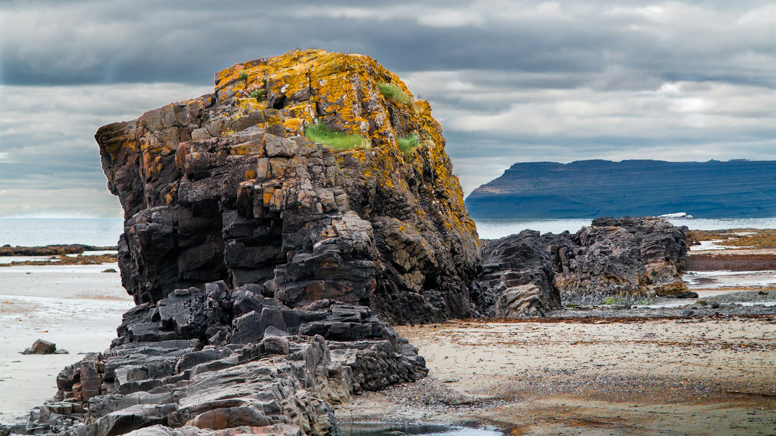 Large rock stack on a rocky coastal foreshore under heavy clouds
