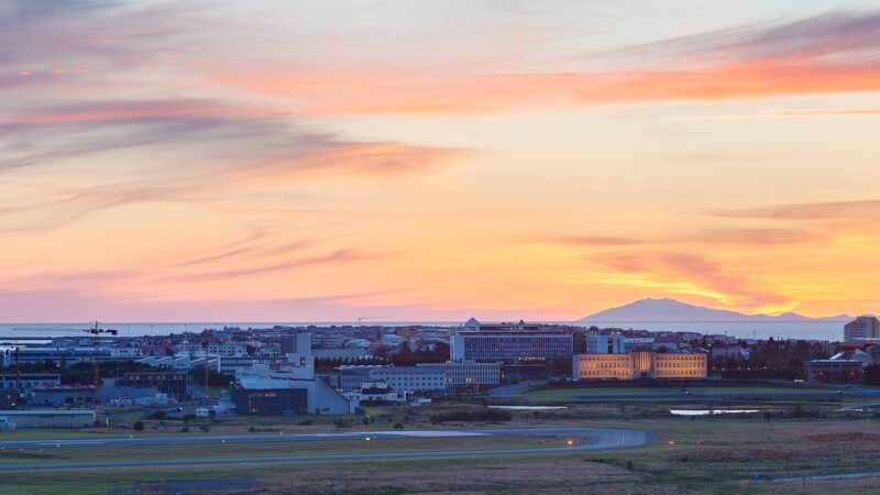 City skyline and coastline at sunset with distant mountains (Reykjavík)