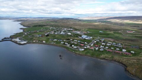 Panoramic drone view of Búðardalur with surrounding farmland and hills (Dalabyggð)
