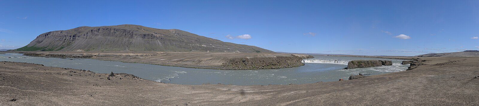 Wide river bend with low plains and a waterfall at right (Skeiða- og Gnúpverjahreppur)