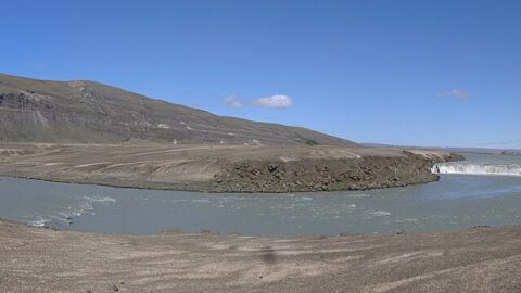Wide river bend with low plains and a waterfall at right (Skeiða- og Gnúpverjahreppur)