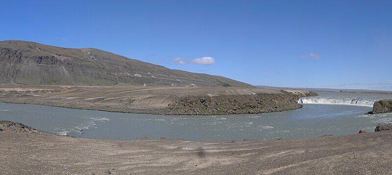 Wide river bend with low plains and a waterfall at right (Skeiða- og Gnúpverjahreppur)