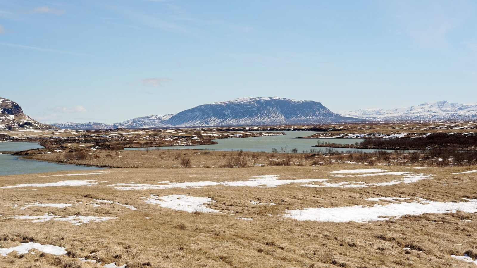 Wide view of a river with meanders and distant mountains