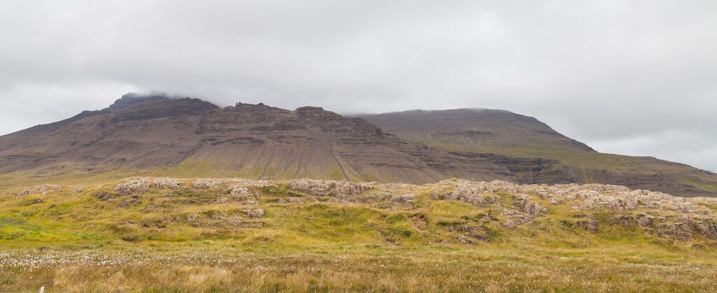 Rocky foothills with grassy foreground and clouds above (Eyja- og Miklaholtshreppur)