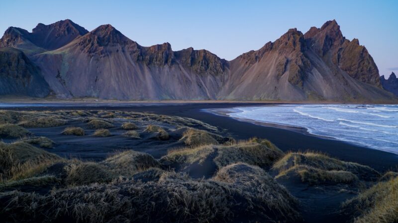 Grassy foreground with a brown mountain rising behind it