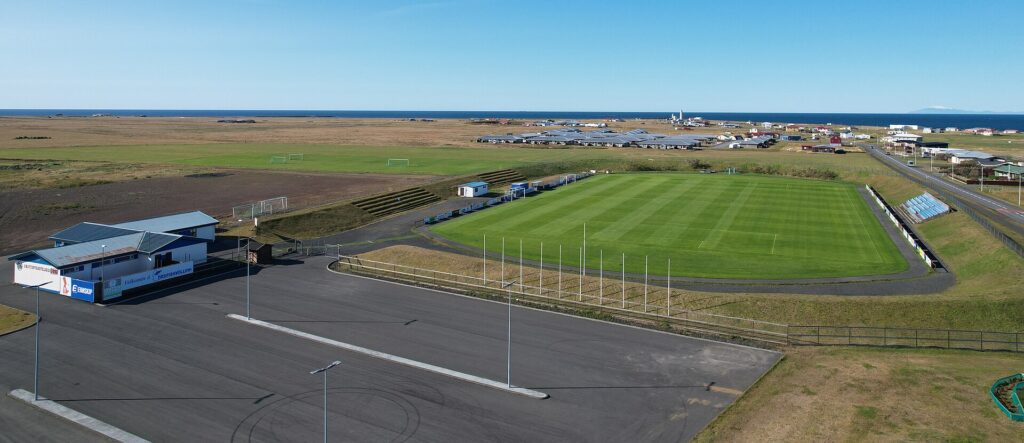 Coastal sports field and low-rise town beyond (Skagagarður)