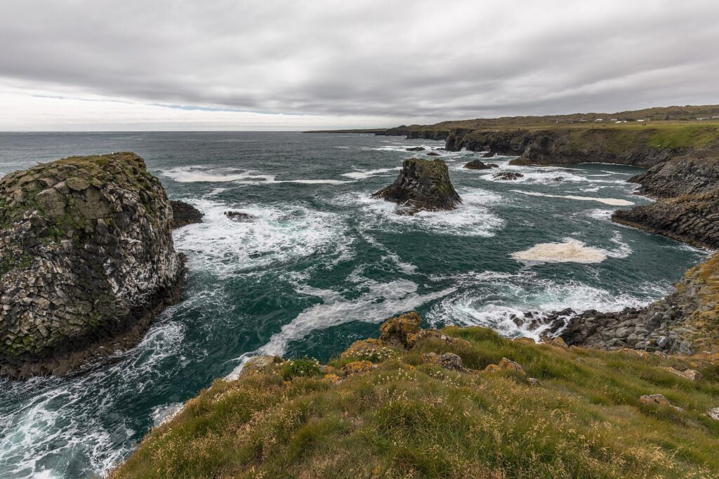 Rugged coastline and sea stacks with waves breaking in the bay (Snæfellsbær)