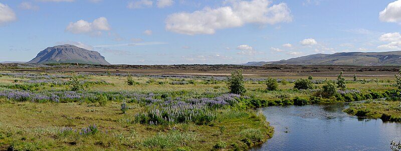 Meandering river through wetlands with distant low mountains (Ásahreppur)