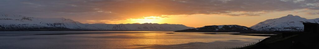 Sunset light reflecting on fjord with silhouetted hills (Grýtubakkahreppur)