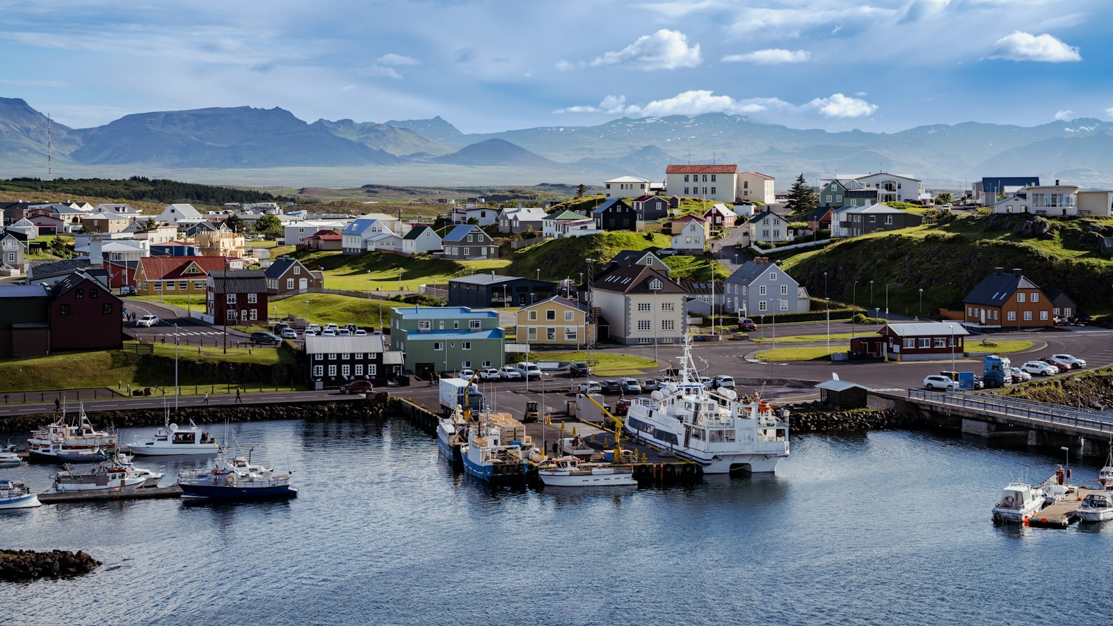Harbour full of boats below a green hillside