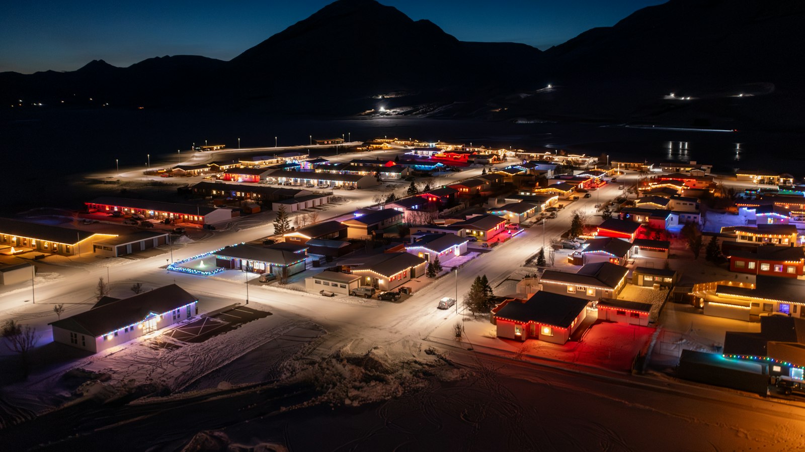 A town in a fjord lit up on a winter night