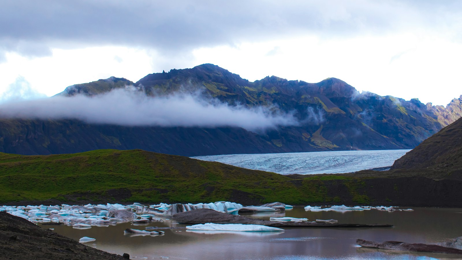 A glacier lagoon with icebergs at the foot of the ice