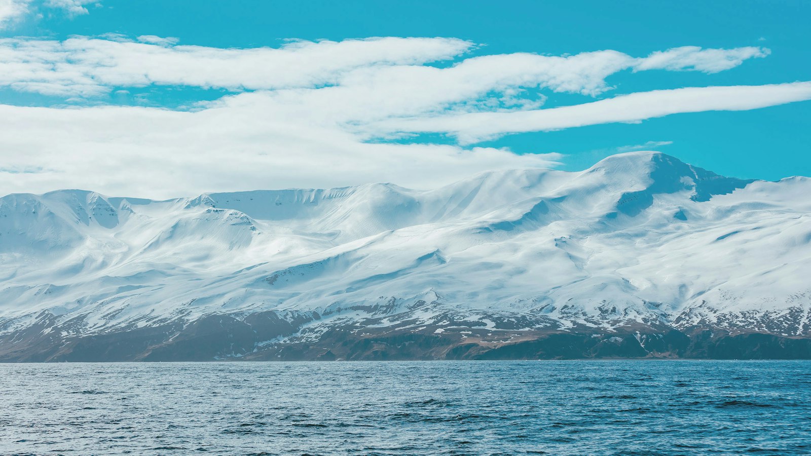 Snow-covered mountain under clouds