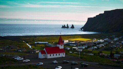 Small village with a red-roofed church by the ocean
