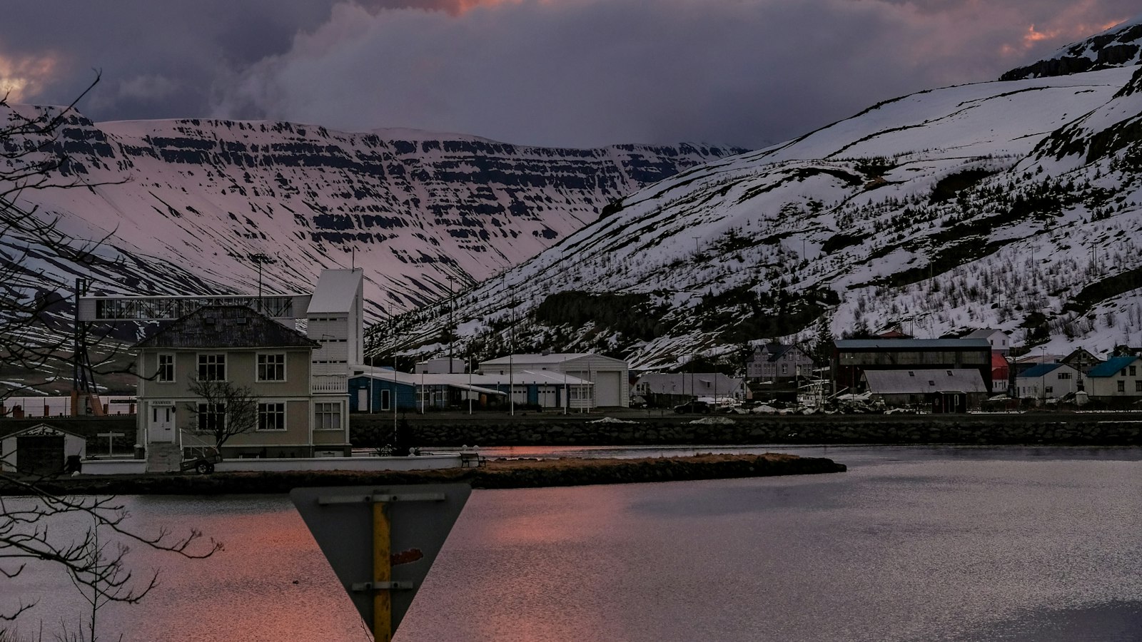 Houses by the water beneath a snowy mountain